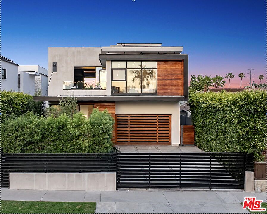 Twilight front elevation of 818 N Curson, a 2018 modern architectural home with walnut wood accents and a dusk Los Angeles sky.