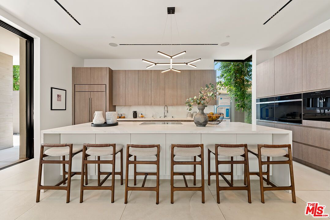 Chef's kitchen with Wolf appliances, stone island, and walnut cabinetry.