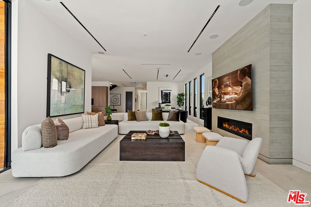 Living room with linear gas fireplace, Italian sectional, and white oak millwork.