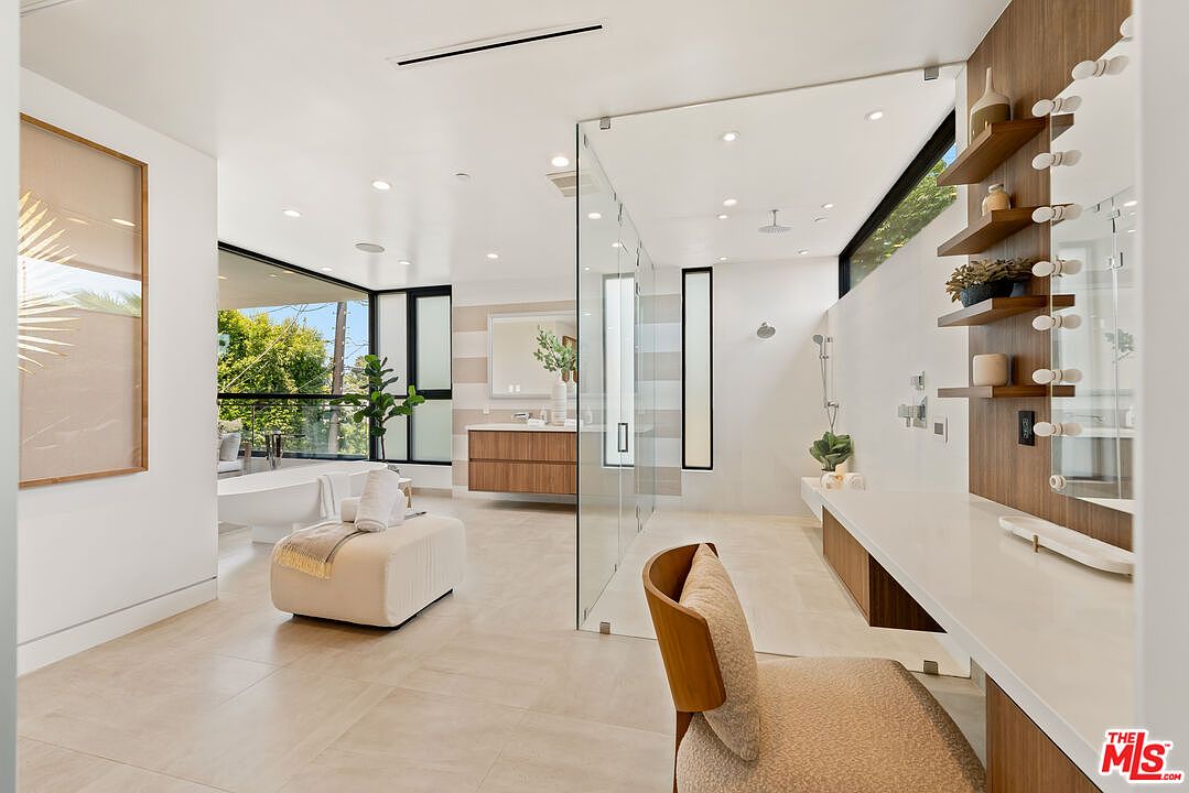 Primary suite spa-like bath with freestanding tub and walk-in rain shower.